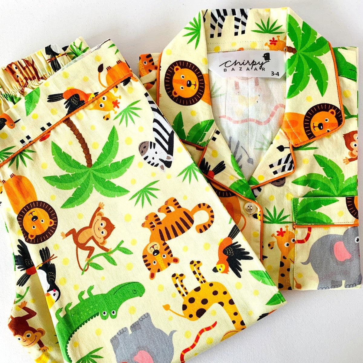 A set of children's pajamas with long sleeves, featuring a colorful safari animals print with characters such as a lion, giraffe, zebra, and elephant.