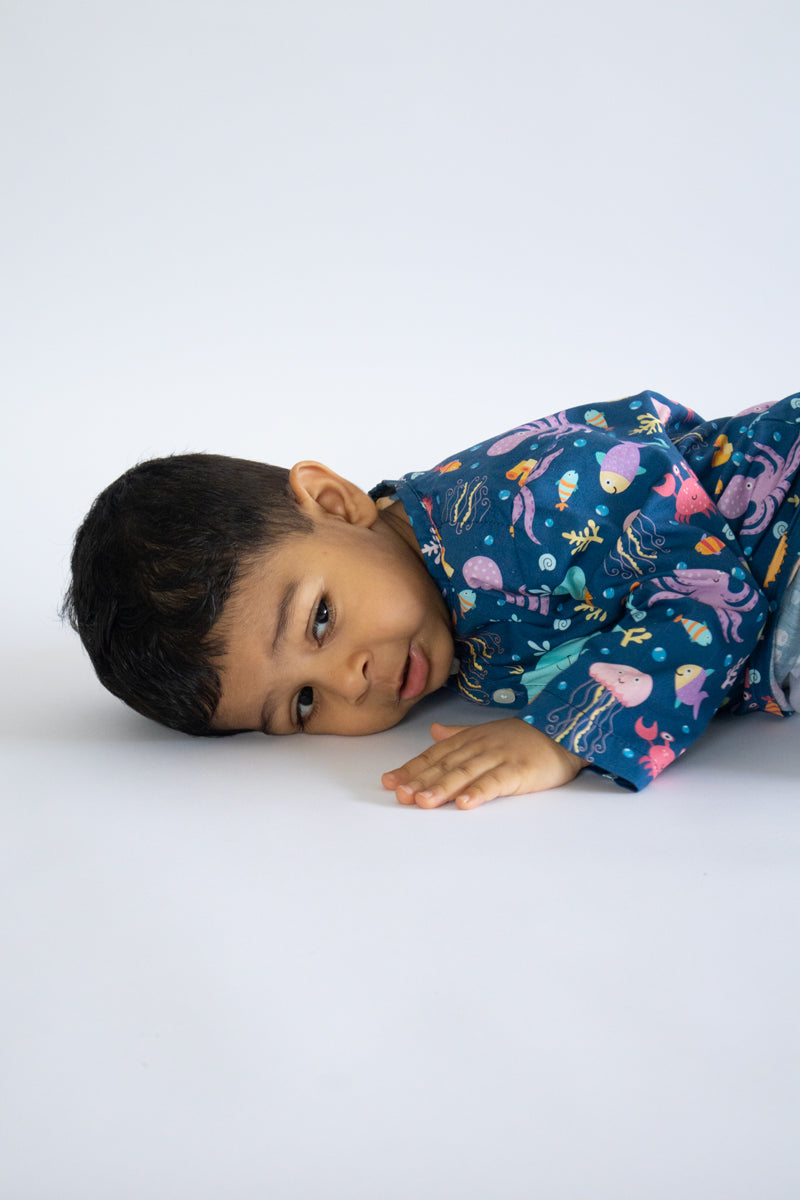 "Kid wearing Kidipoo sea creatures print cotton kurta pajama set lying pose soft cotton outfit"