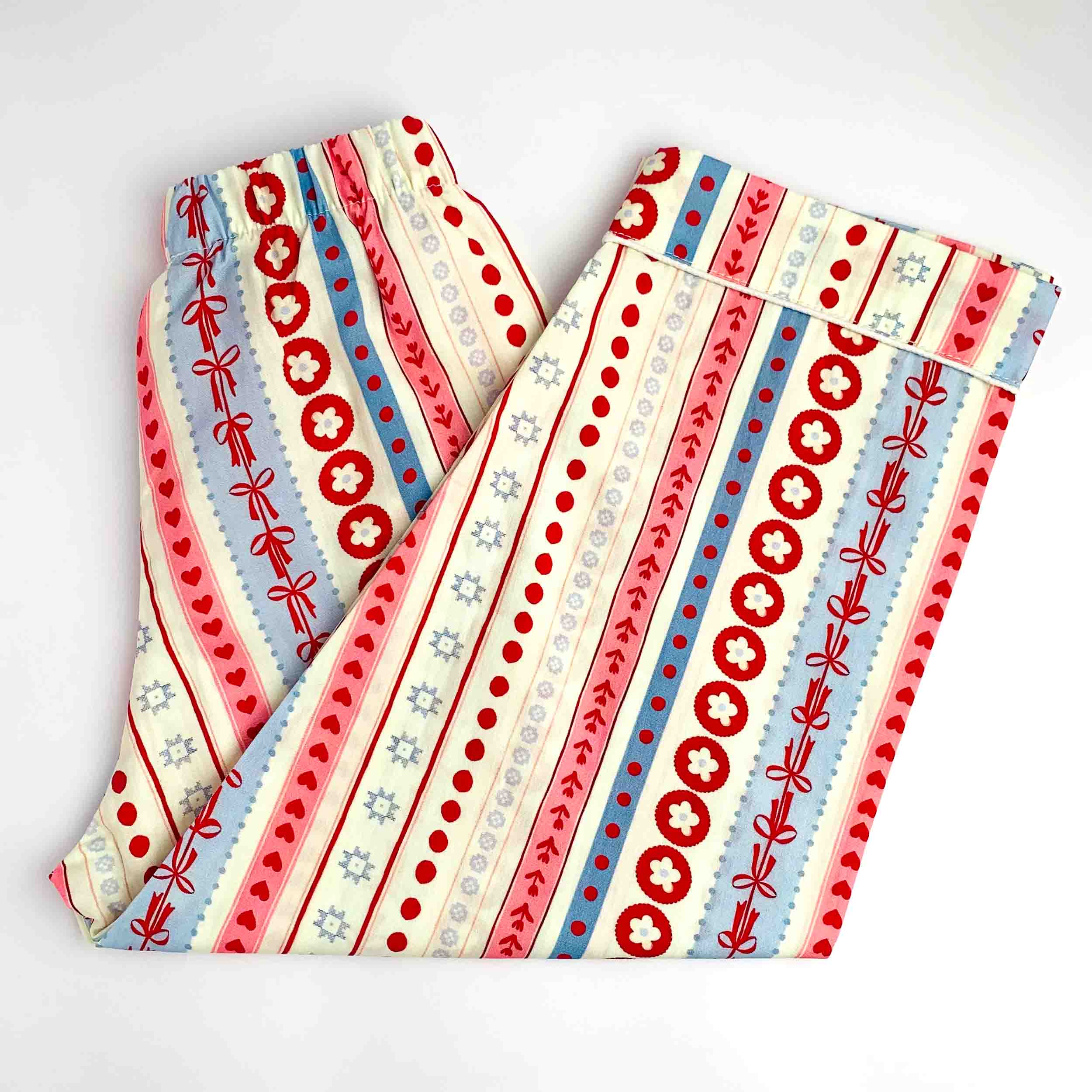 Kids printed full-length night suit pants featuring red, blue, and cream stripes, dots, and heart pattern with elastic waist