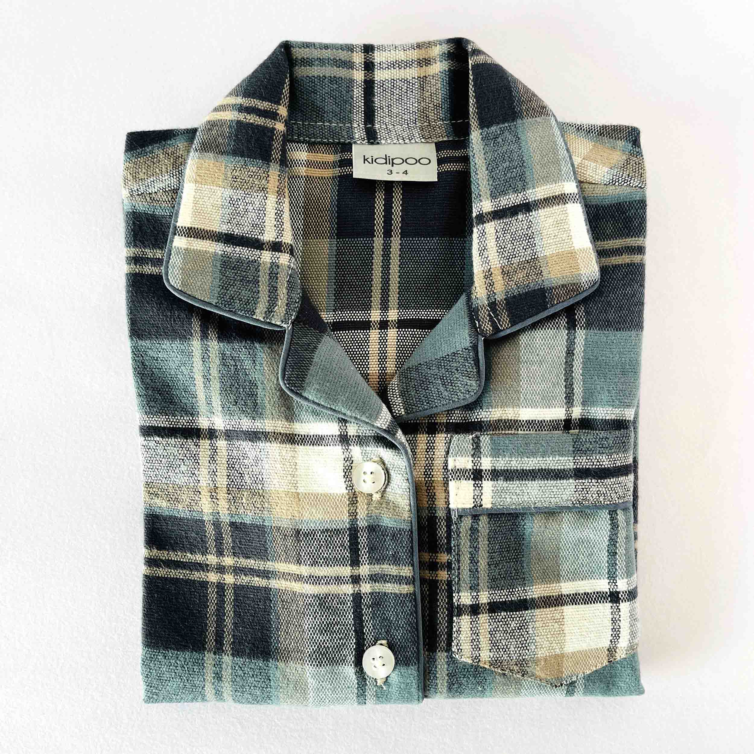 Folded plaid shirt with 'kidipoo' label on a white background