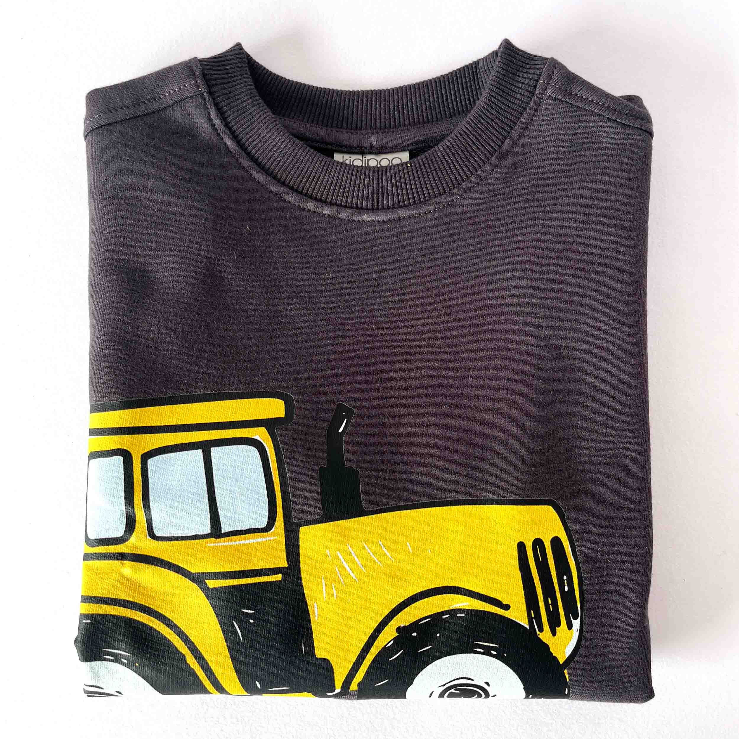Folded dark gray sweatshirt with a yellow tractor design on a white background