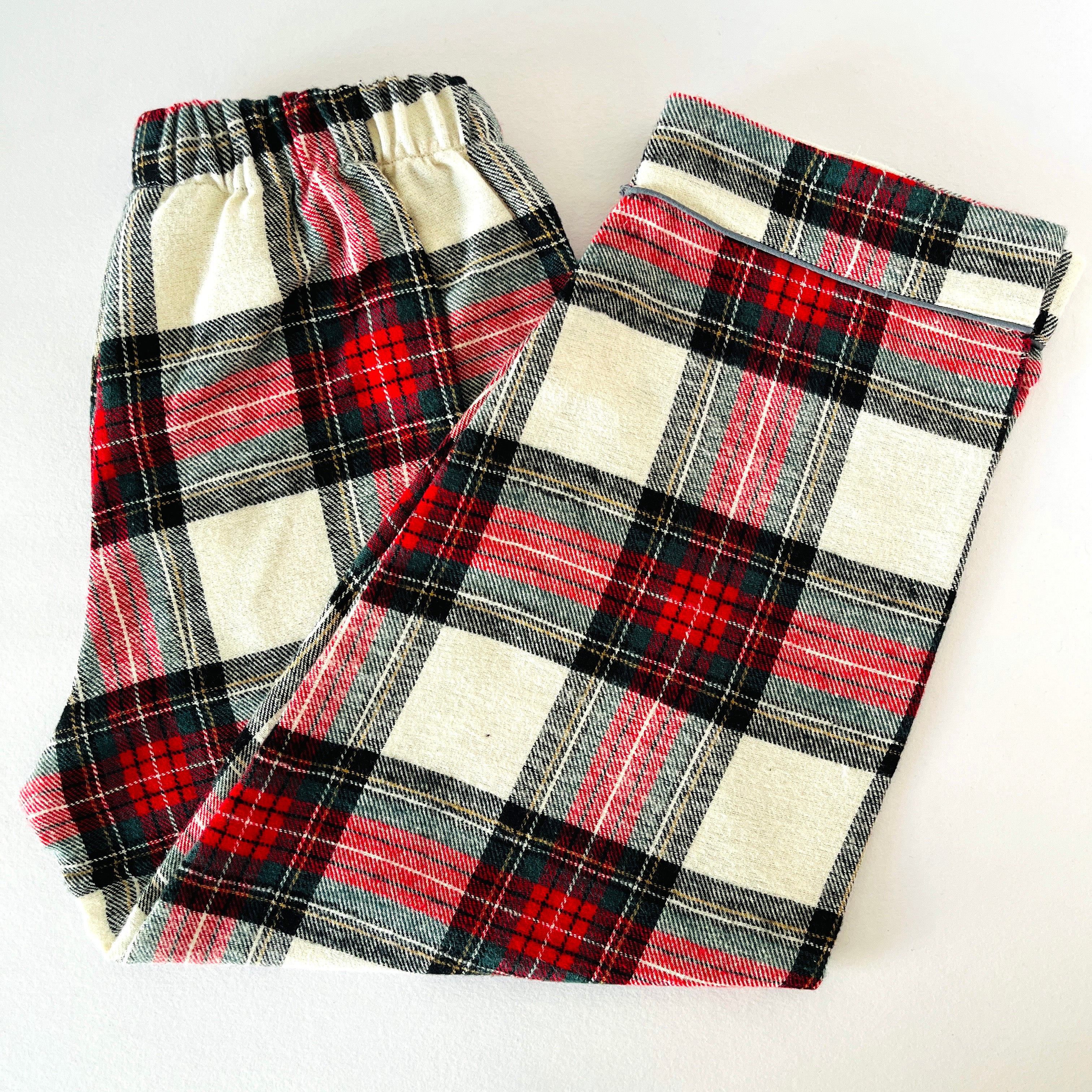 Plaid fabric with red, black, and white pattern on a white background