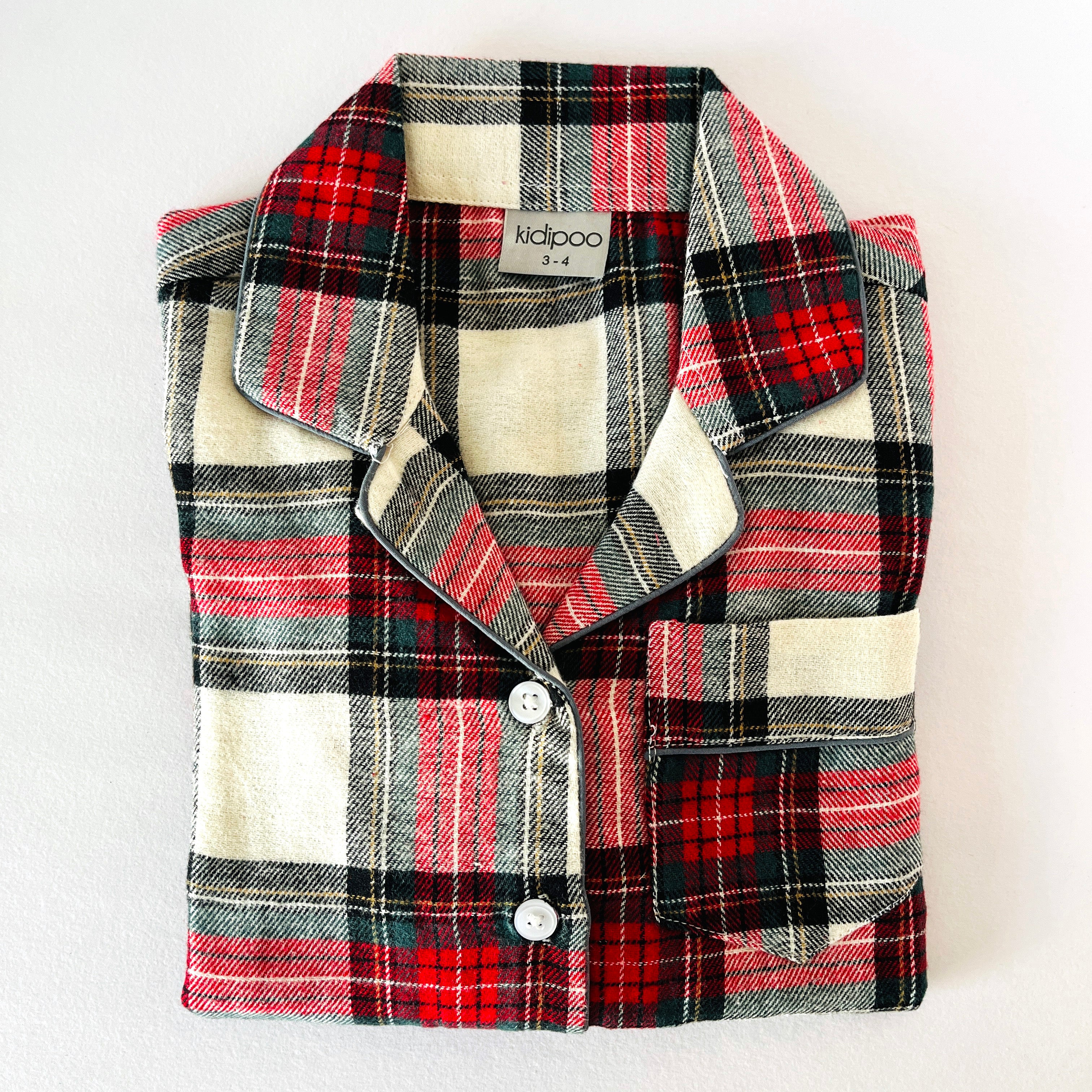 Folded plaid shirt with visible brand name on a white background