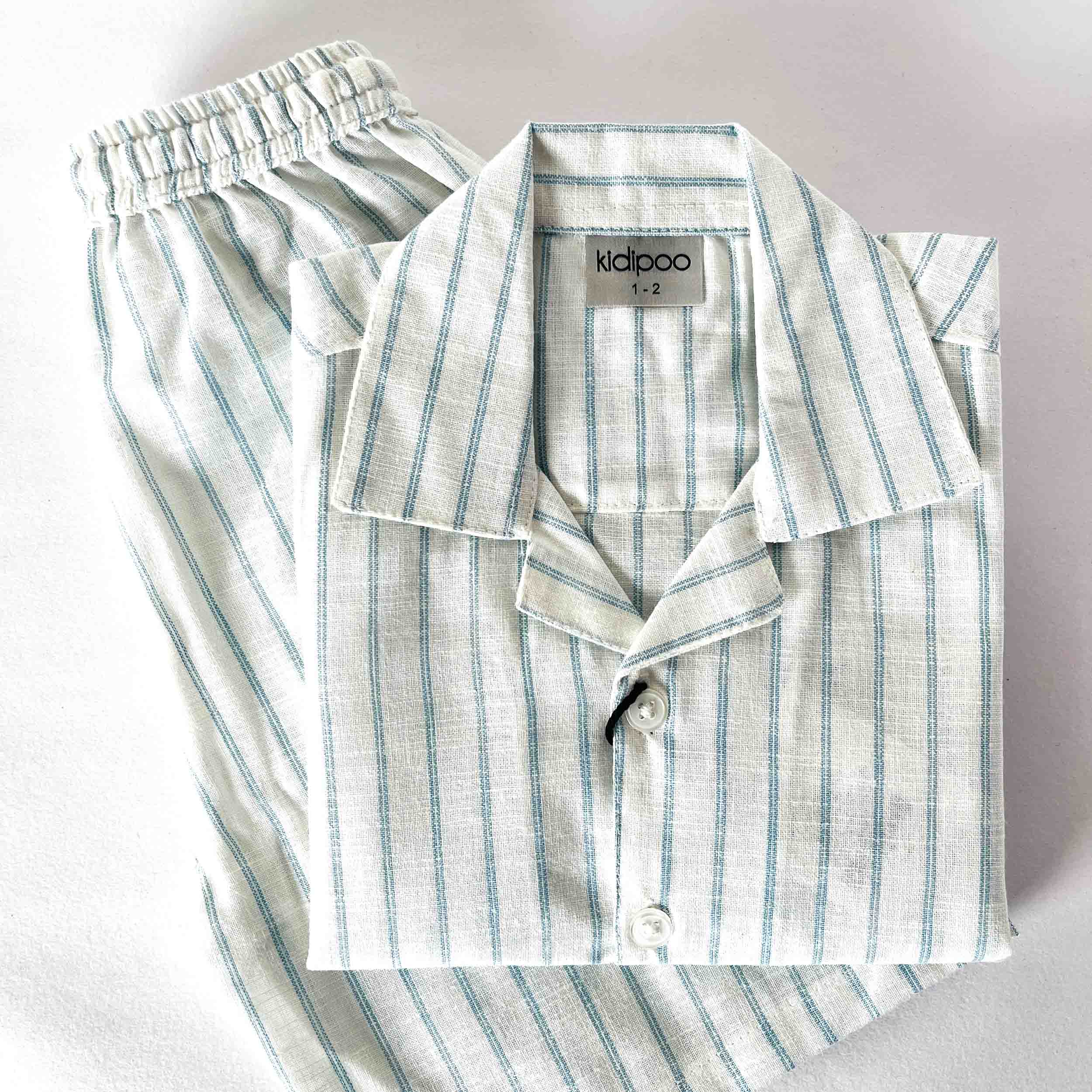 Kids striped nightwear set with collared button-down shirt and matching striped shorts on a light background