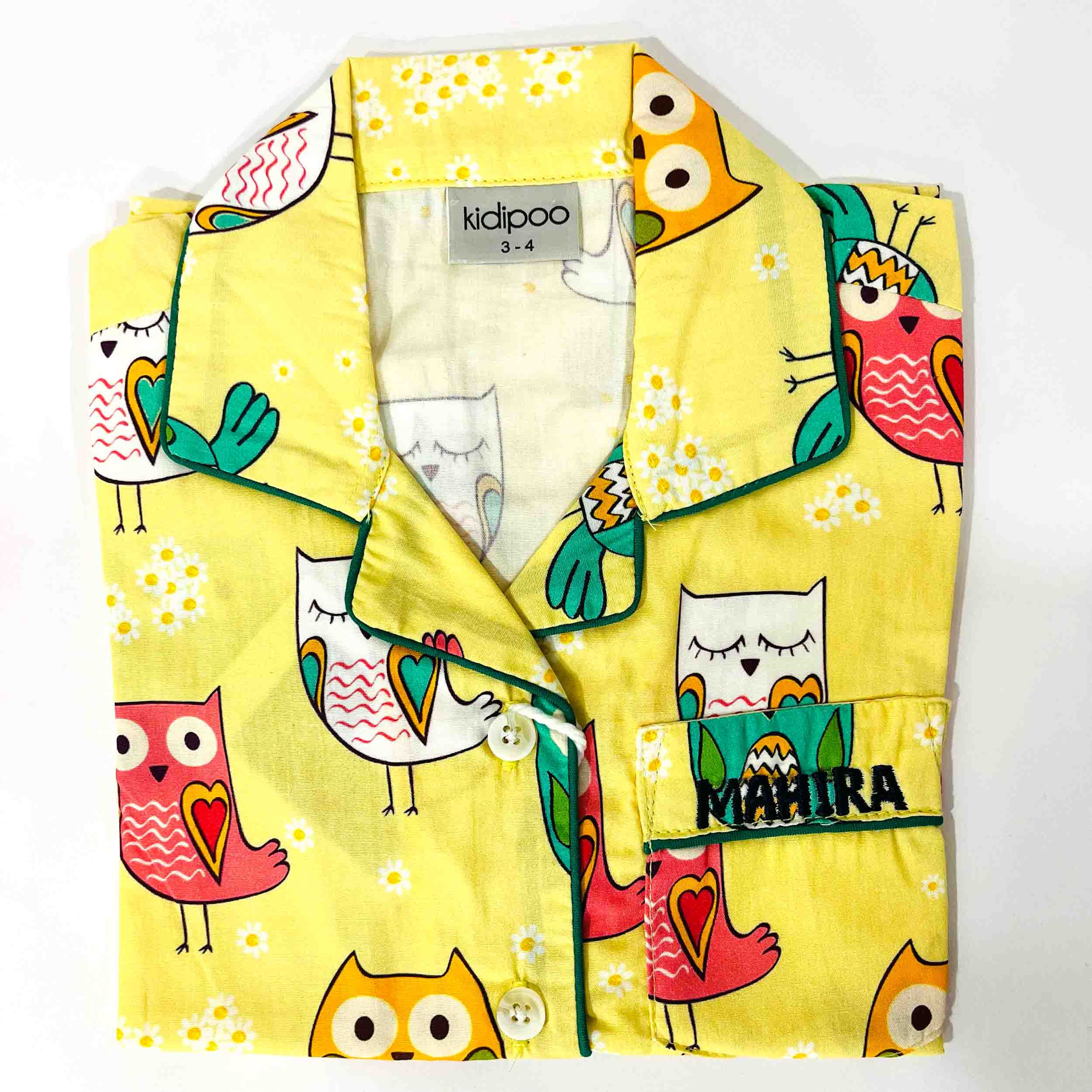 Yellow children's shirt with colorful owl designs on a white background